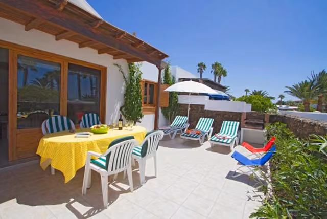 Patio esterno con tavolo, sedie e ombrellone del B&B Flamingo